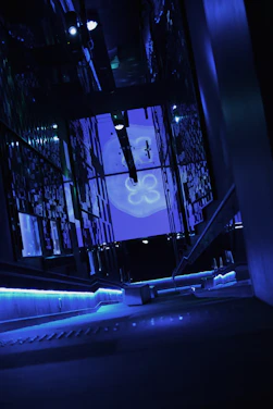 A sleek, futuristic workspace glowing with neon blue and purple lights, featuring a holographic AI interface.