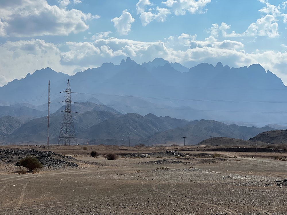 a dirt field with mountains in the background