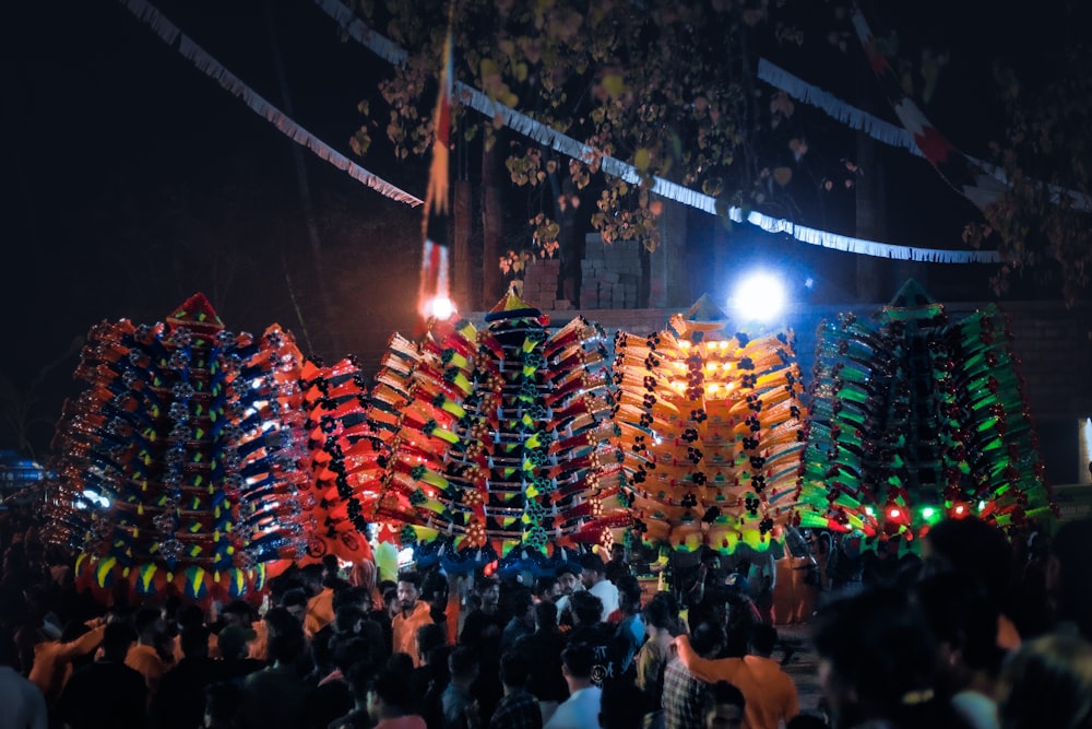 a crowd of people standing around a display of kites