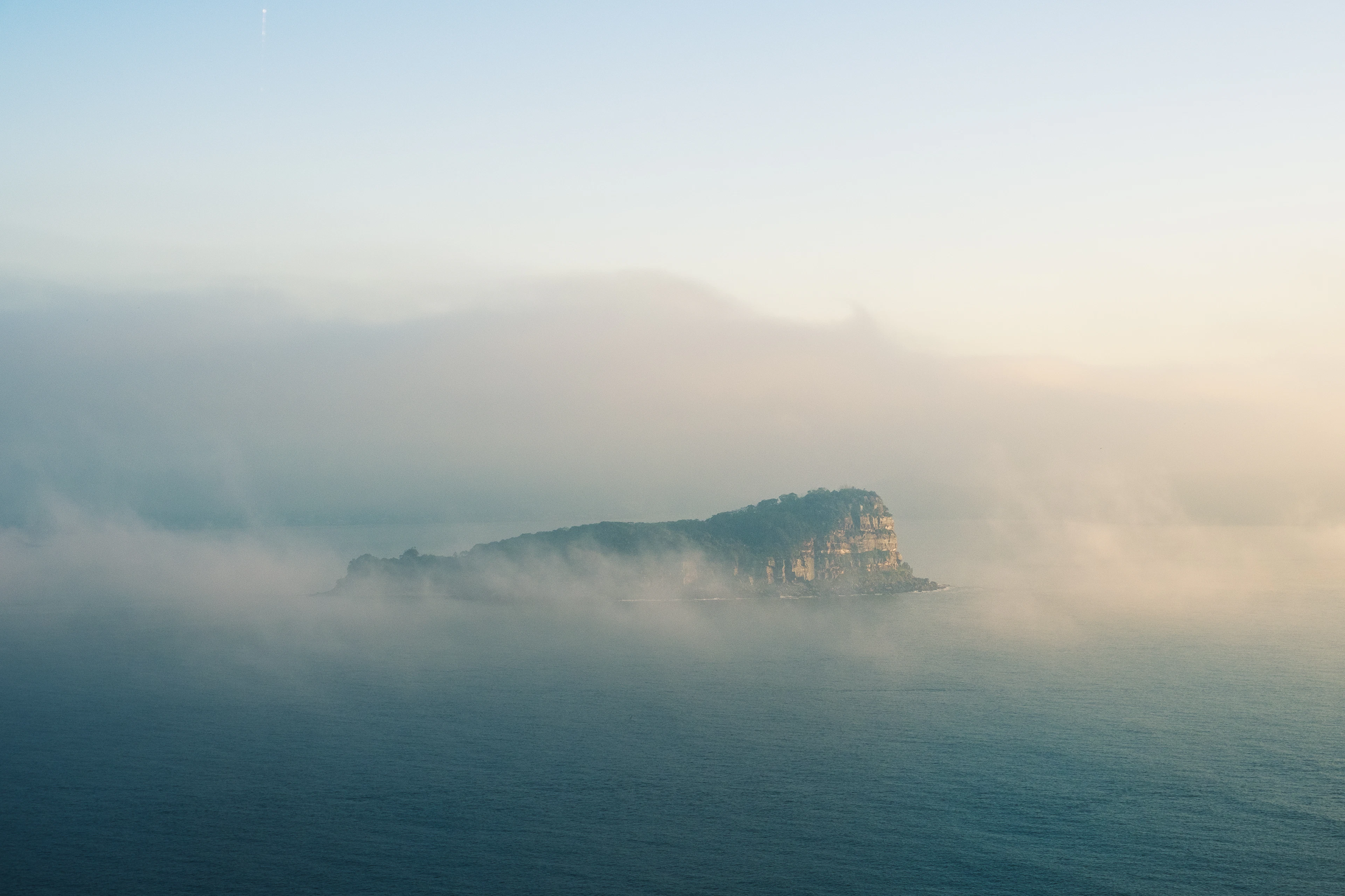 Mountain peaks emerging from a layer of morning mist