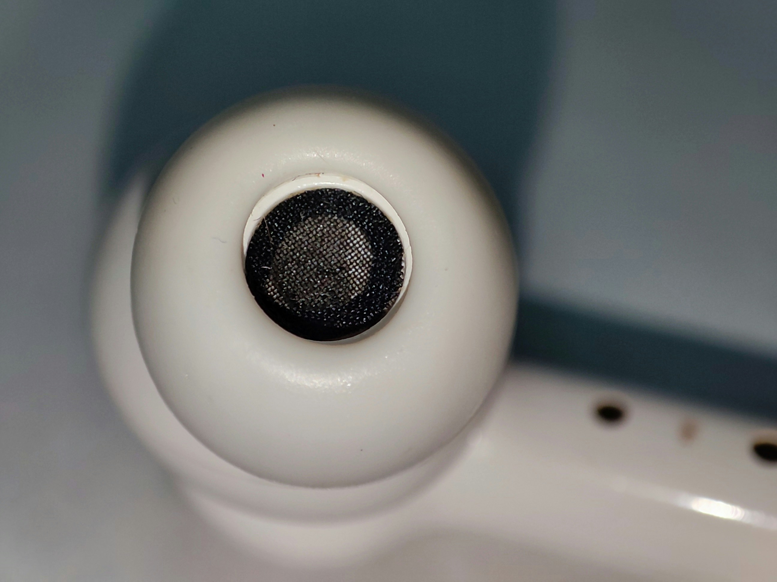 Close-up of wireless earbud showing speaker mesh and controls