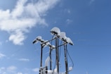 A Hydro One technician inspecting high-voltage power lines against a clear blue sky.