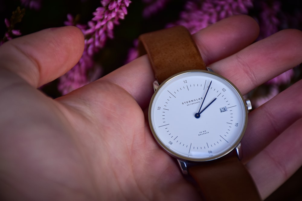 a person holding a watch in their hand