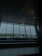 An elegant corporate office with floor-to-ceiling windows overlooking a bustling international airport.