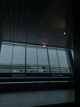 A sleek corporate office with a large window overlooking an airport runway bathed in soft morning light.