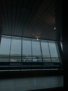 A panoramic shot capturing wide windows with calming airport runway views and soft ambient lighting