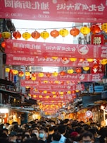 A joyful crowd waving banners with the bingwu logo during a Chinese New Year street festival.