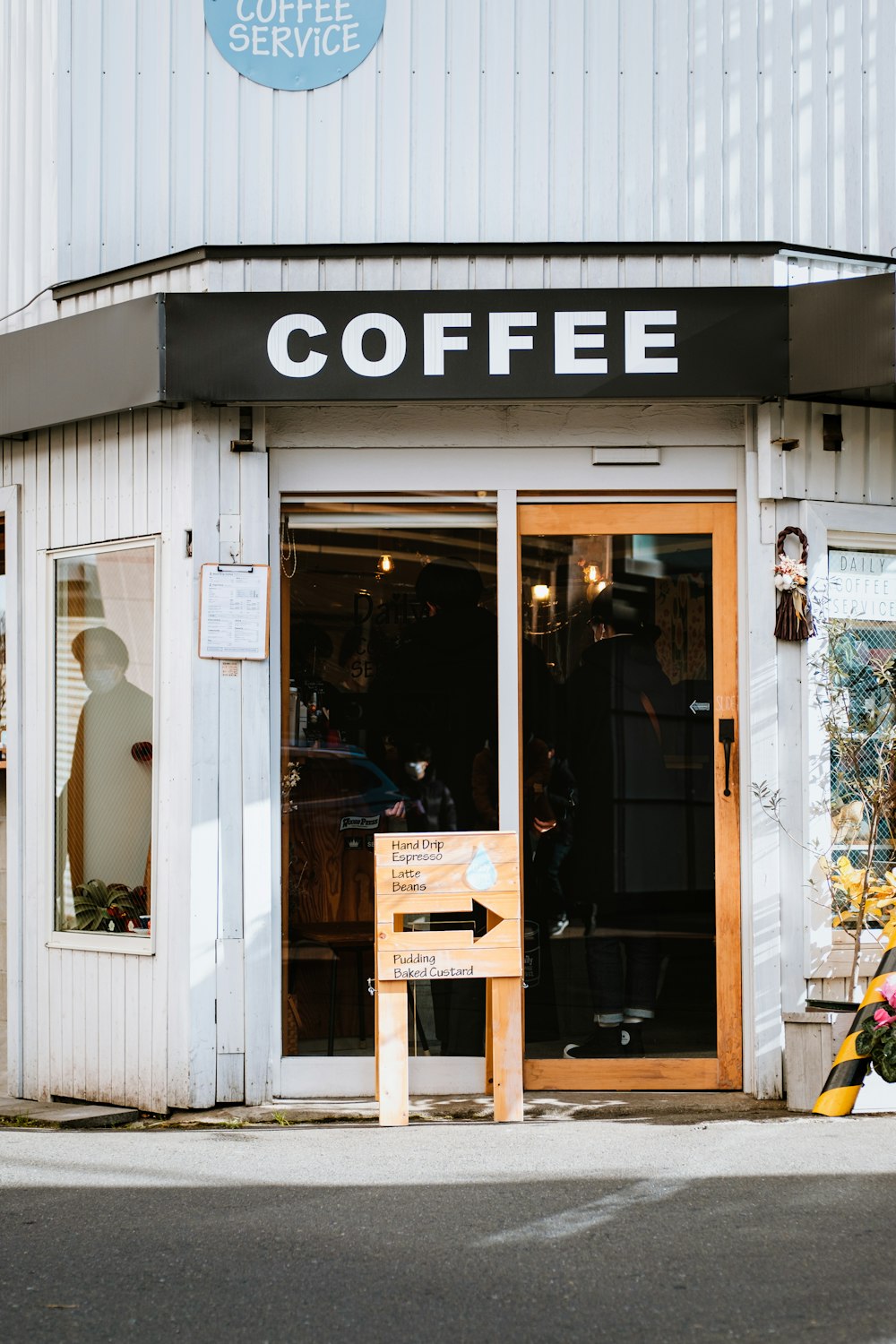 a coffee shop with a sign in front of it