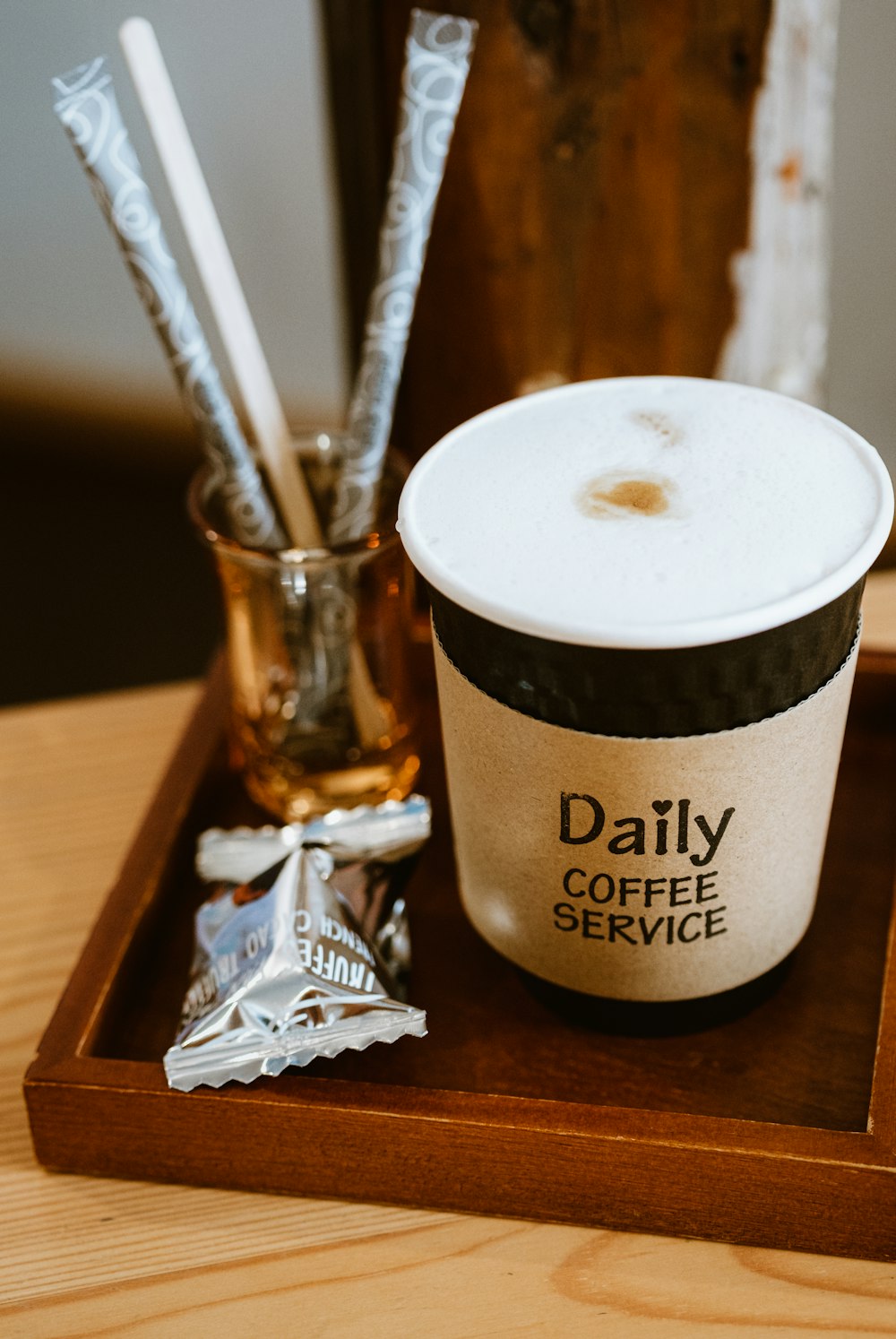 a cup of coffee sitting on top of a wooden tray