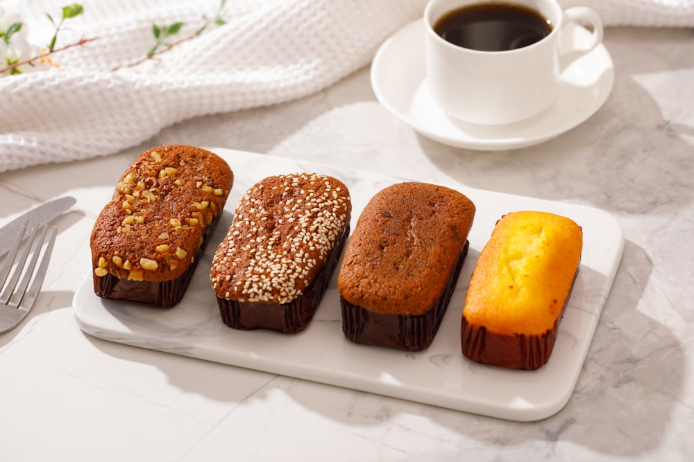 a white plate topped with four different types of cakes