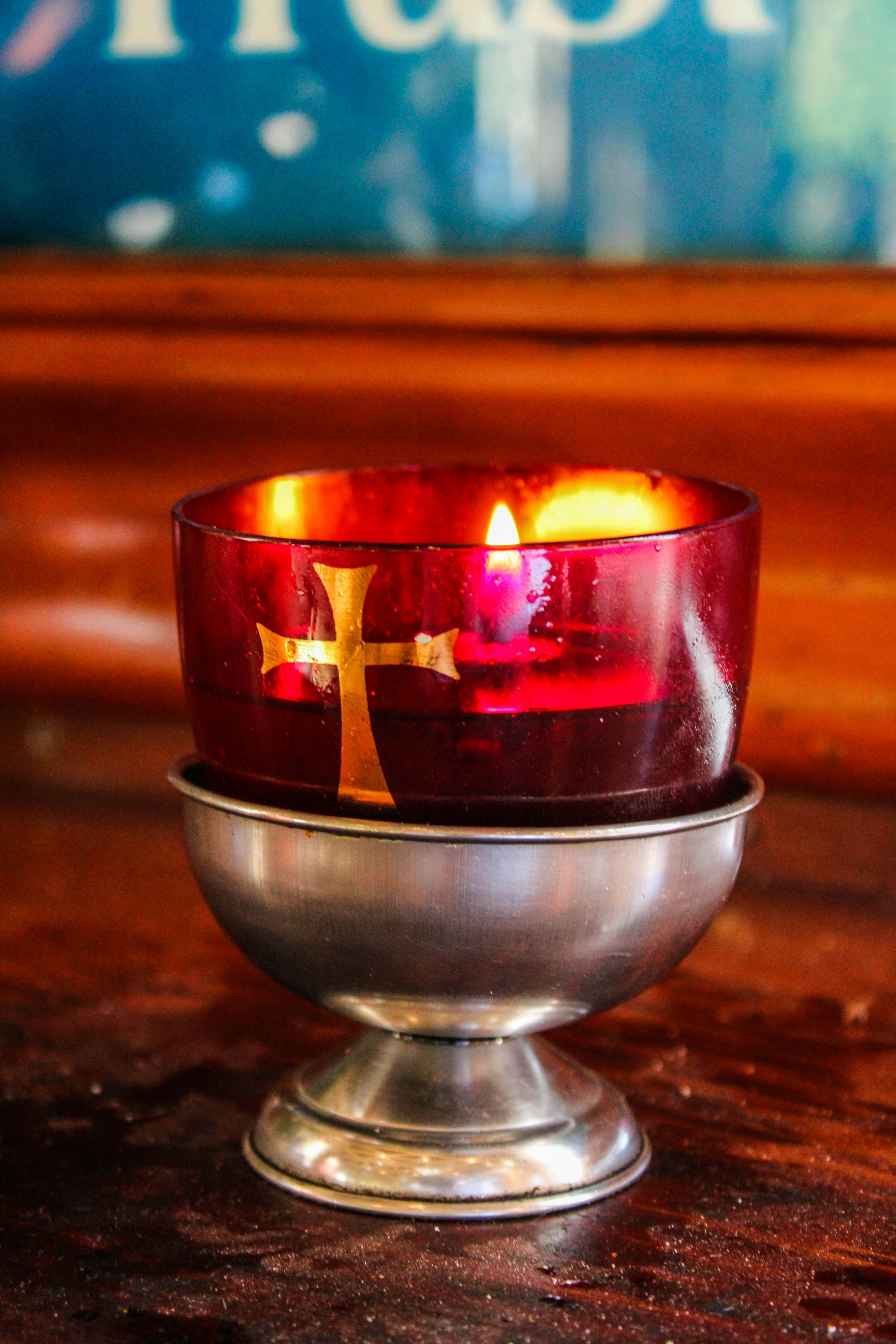 Elegant cream gift box with gold ribbon containing a small cross, scripture card, and candle, styled on a wooden surface
