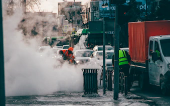 a man in an orange safety vest standing in the middle of a street