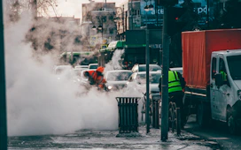 a man in an orange safety vest standing in the middle of a street