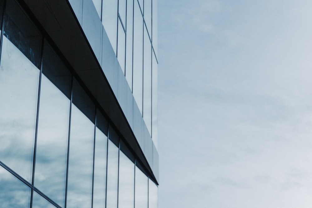 a tall glass building with a sky in the background