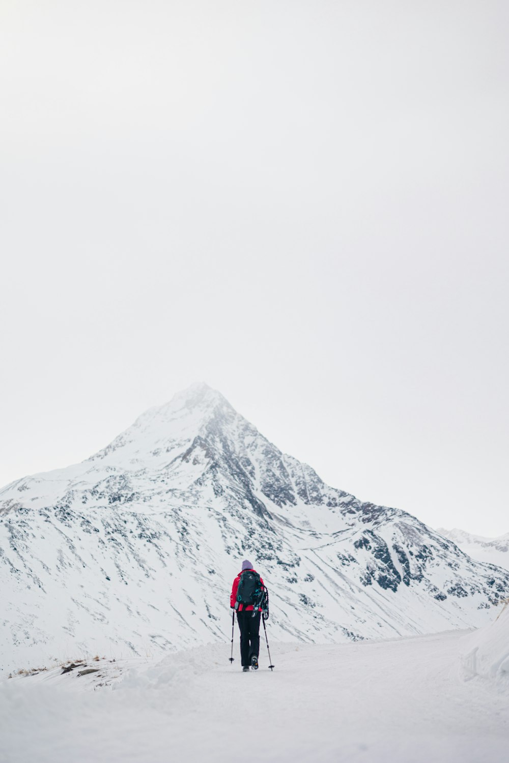 a person on skis in the snow near a mountain