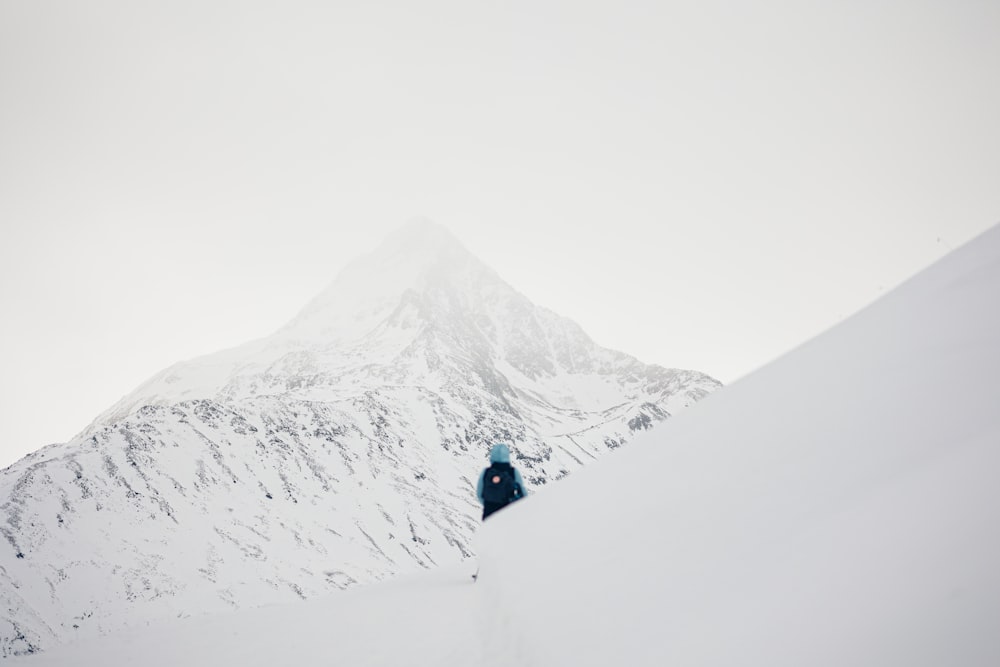 a person standing on top of a snow covered mountain