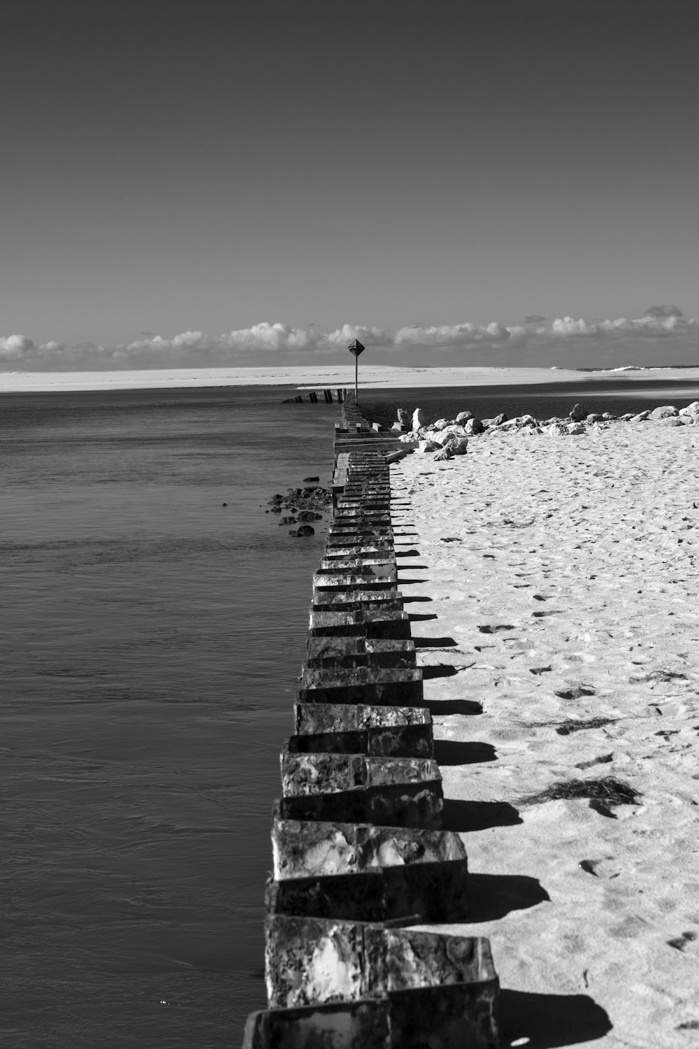 a black and white photo of a long wooden pier