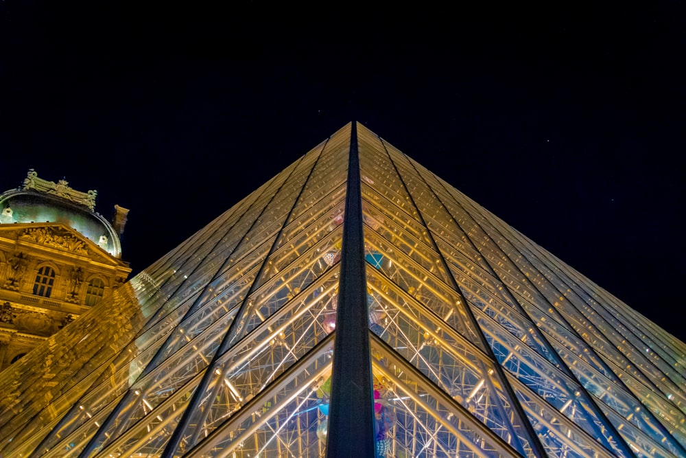 a very tall glass pyramid with a clock on top