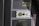 A close-up of a control panel featuring an evacuation alert section with a speaker, button, and label. The panel has a textured surface with the word 'EXIT' visible on the side in red letters.