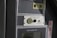 A close-up of a control panel featuring an evacuation alert section with a speaker, button, and label. The panel has a textured surface with the word 'EXIT' visible on the side in red letters.