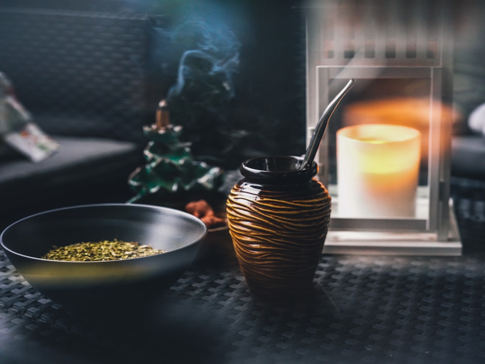a candle and a bowl on a table