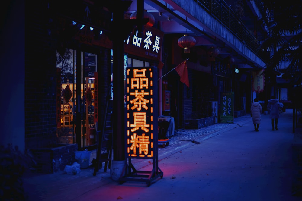 a lighted sign on the side of a building