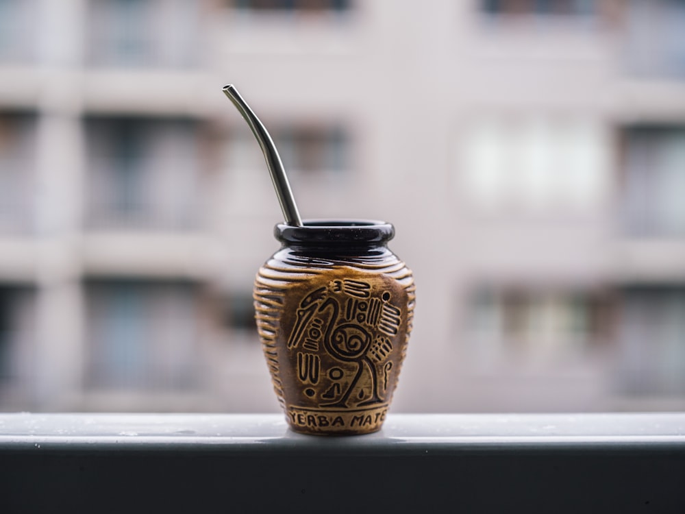 a vase with a straw sticking out of it