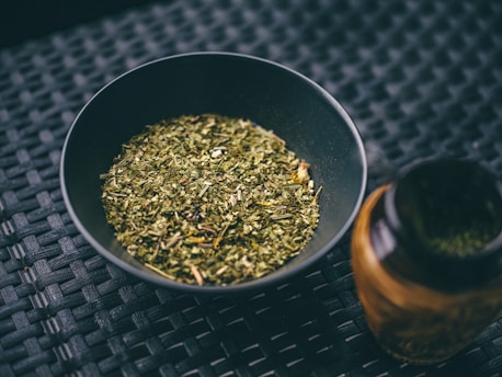 a bowl filled with green tea next to a bottle