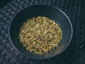 a black bowl filled with a mixture of herbs
