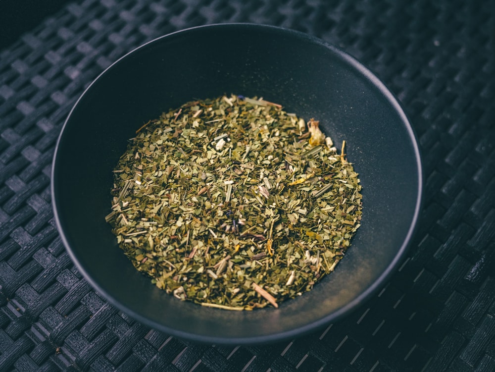 a black bowl filled with a mixture of herbs