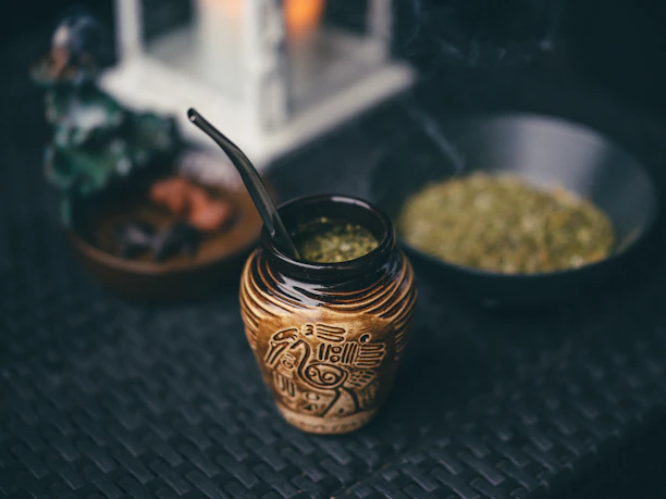 Close-up of beautifully crafted mate cups and bombillas displayed on a wooden table.