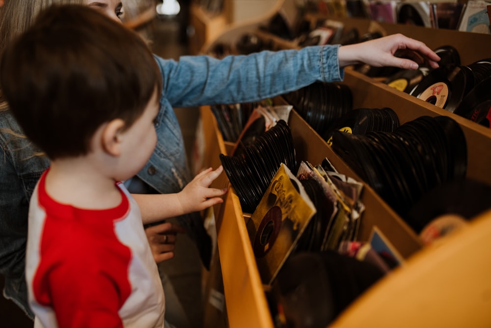 a young child looking through a drawer at a pair of shoes