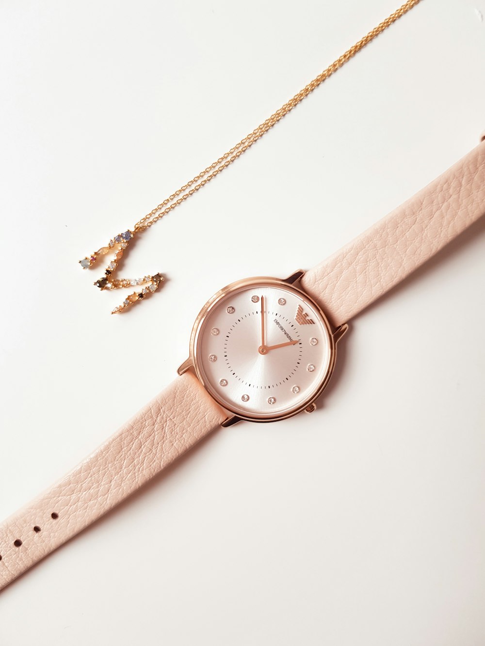 a pink watch sitting on top of a white table