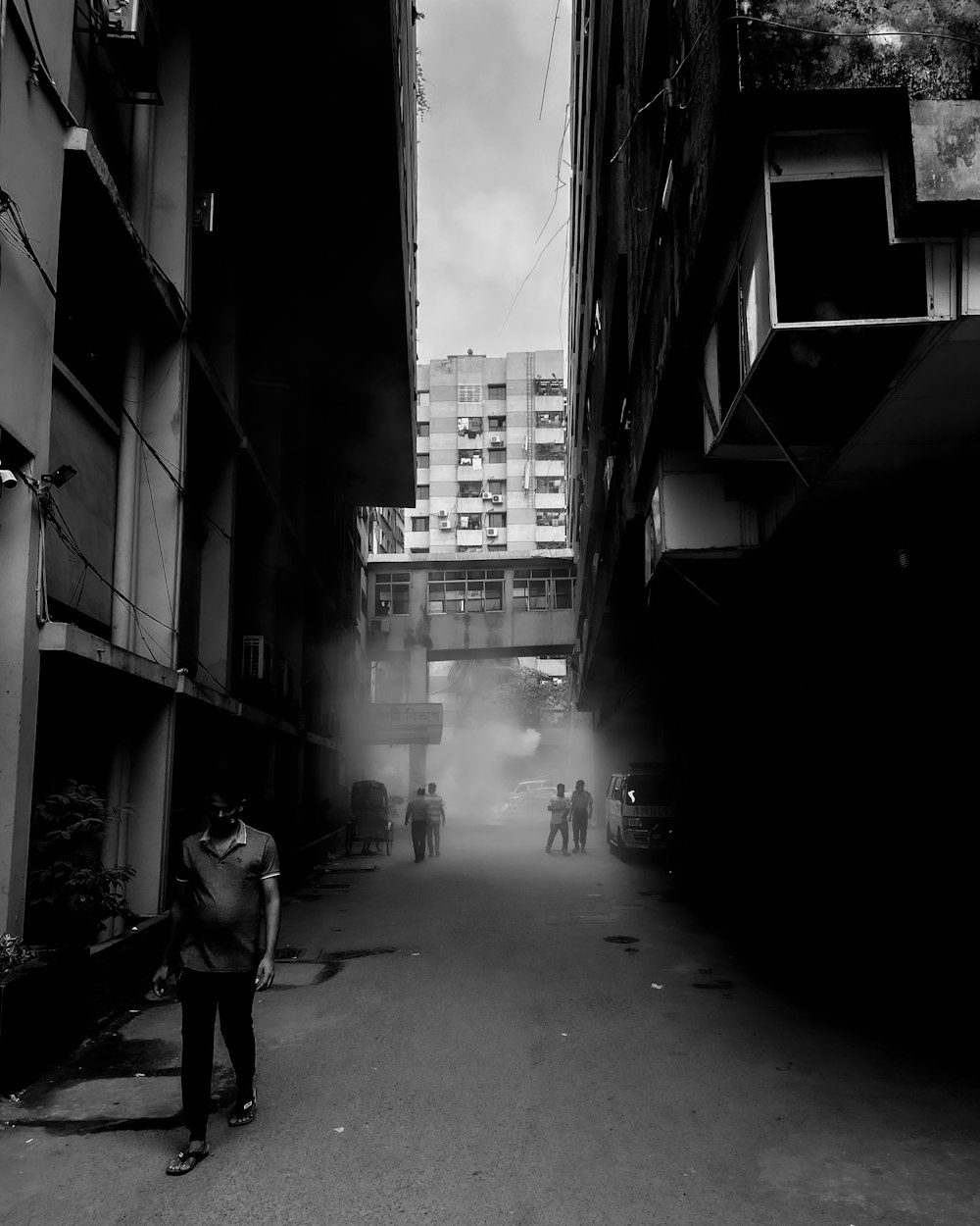 a black and white photo of a man walking down a street