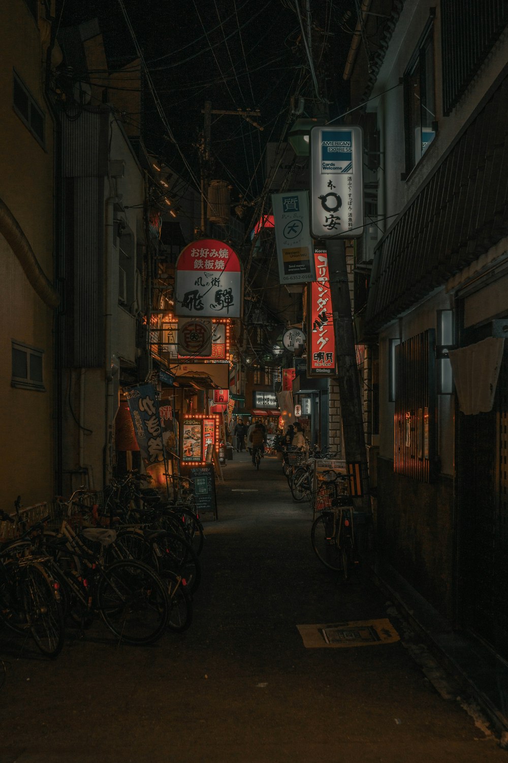 a narrow alley with many bikes parked on the side of it