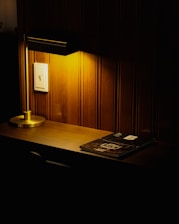 a desk with a lamp and a book on it