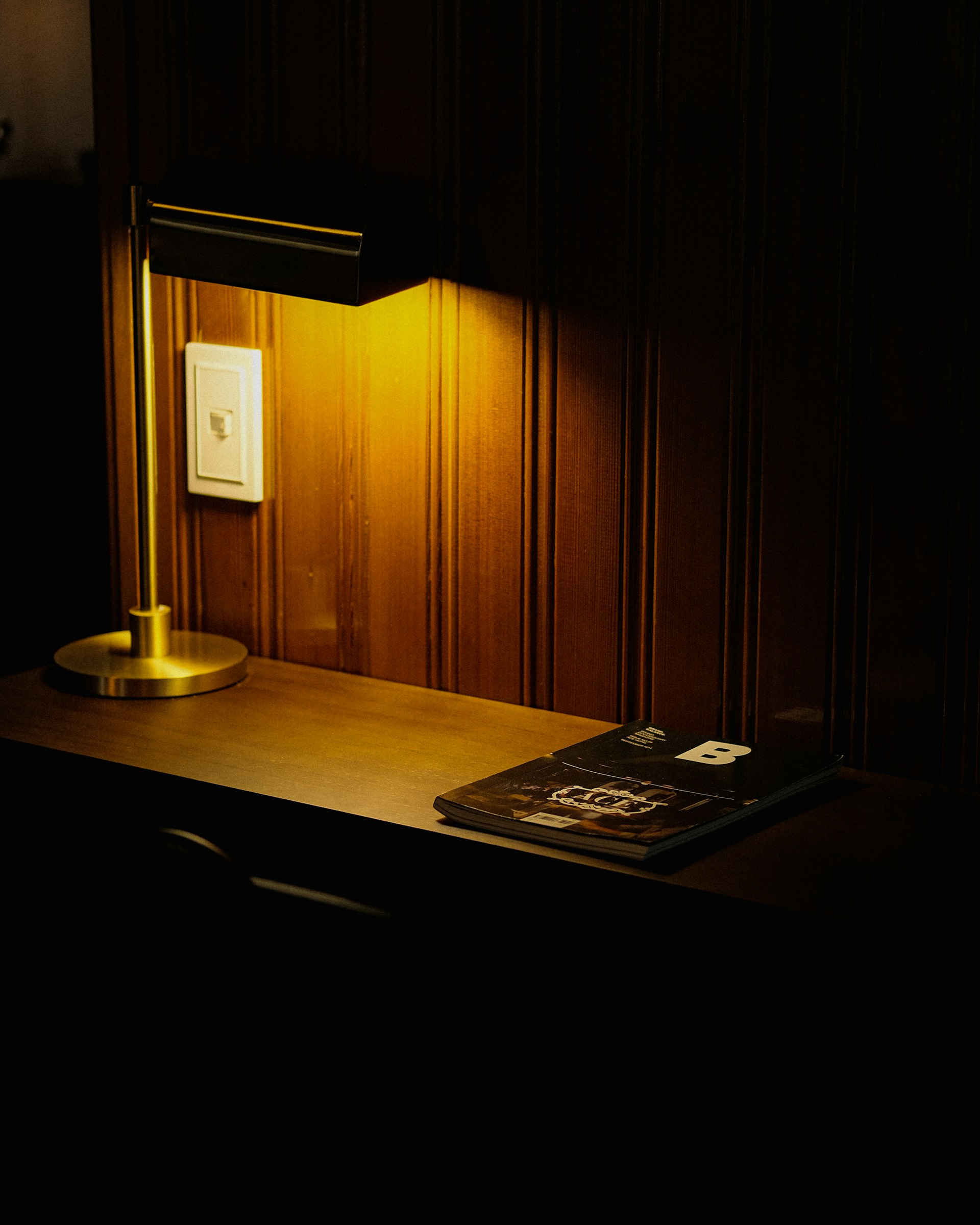 a desk with a lamp and a book on it