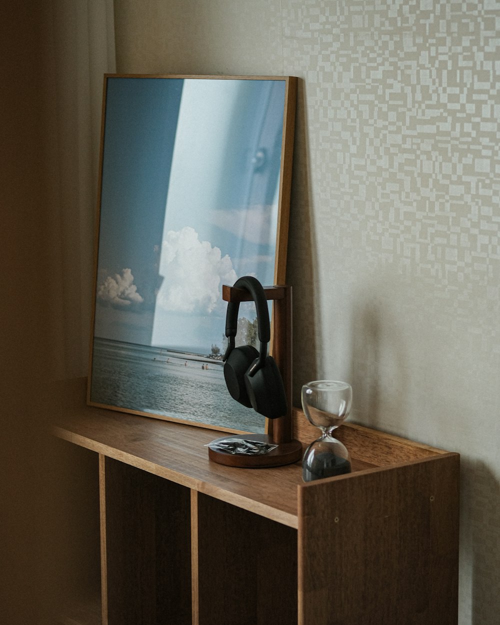a wooden shelf with a picture and a wine glass on it
