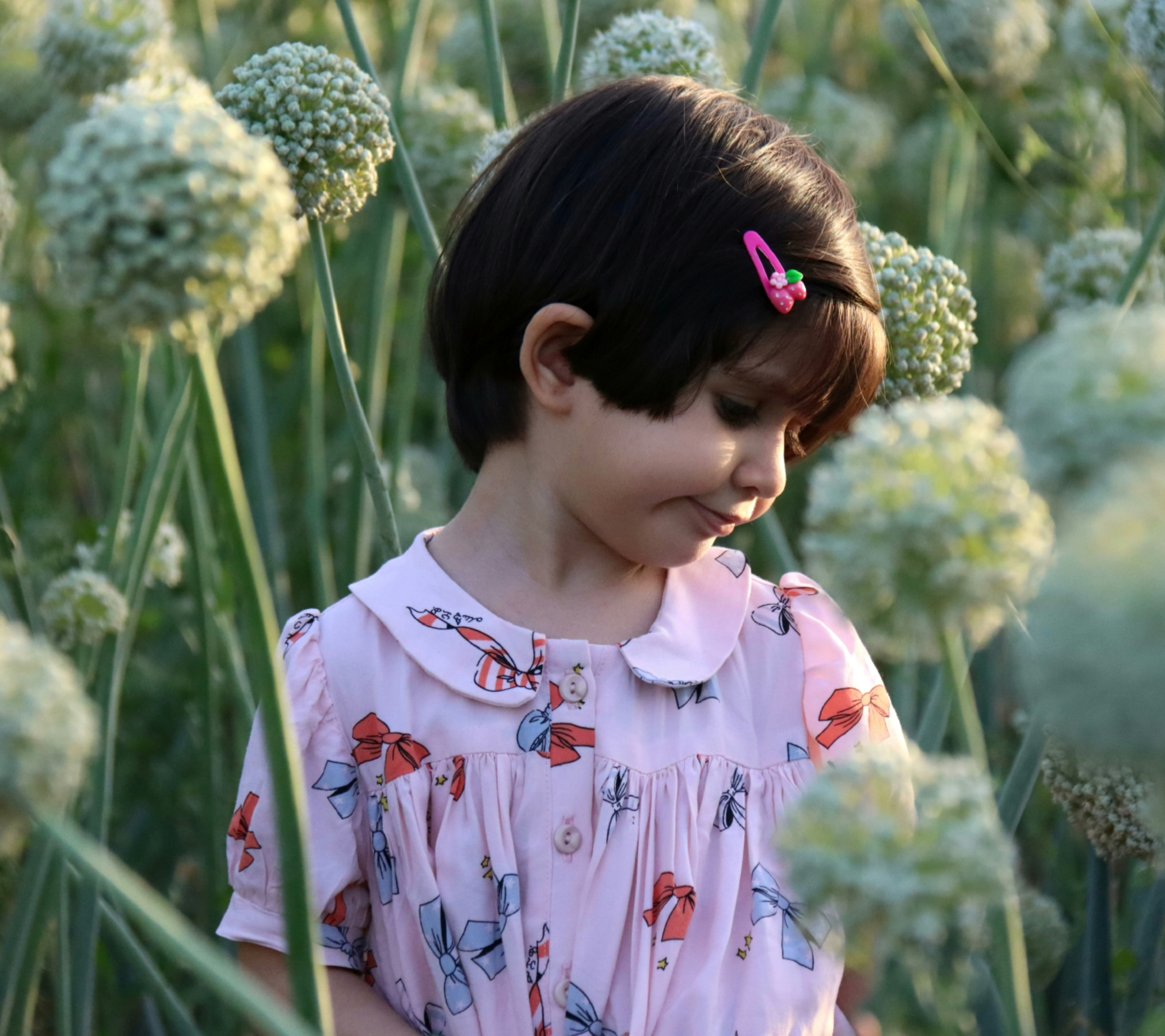 Une petite fille debout dans un champ de fleurs