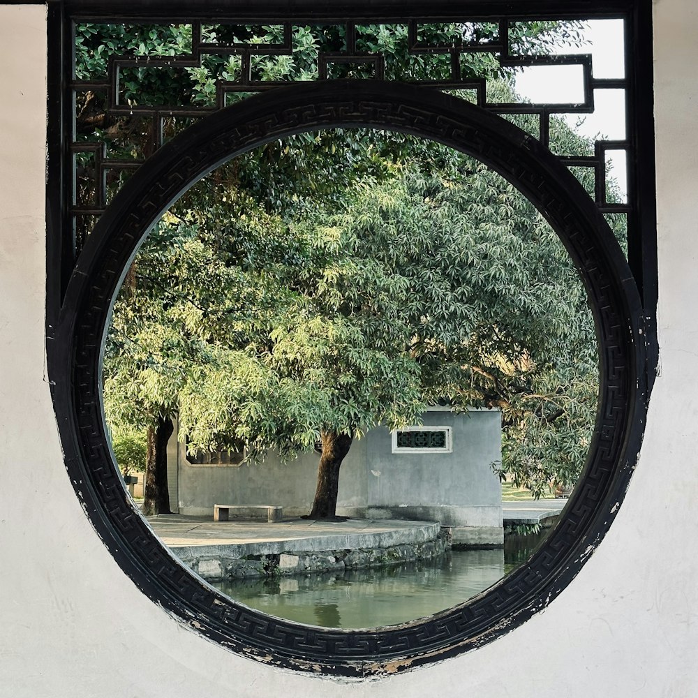 a circular mirror hanging on the side of a wall