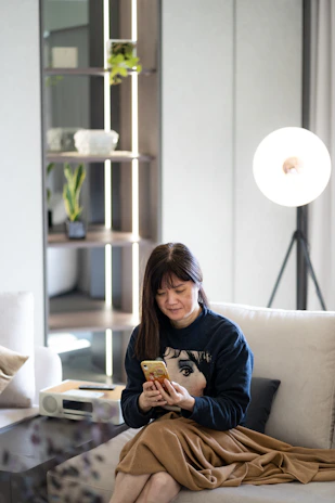 A relaxed woman lounging in stylish homewear in a bright, modern living room.