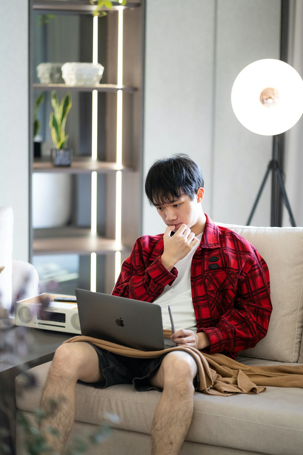 a man sitting on a couch using a laptop computer