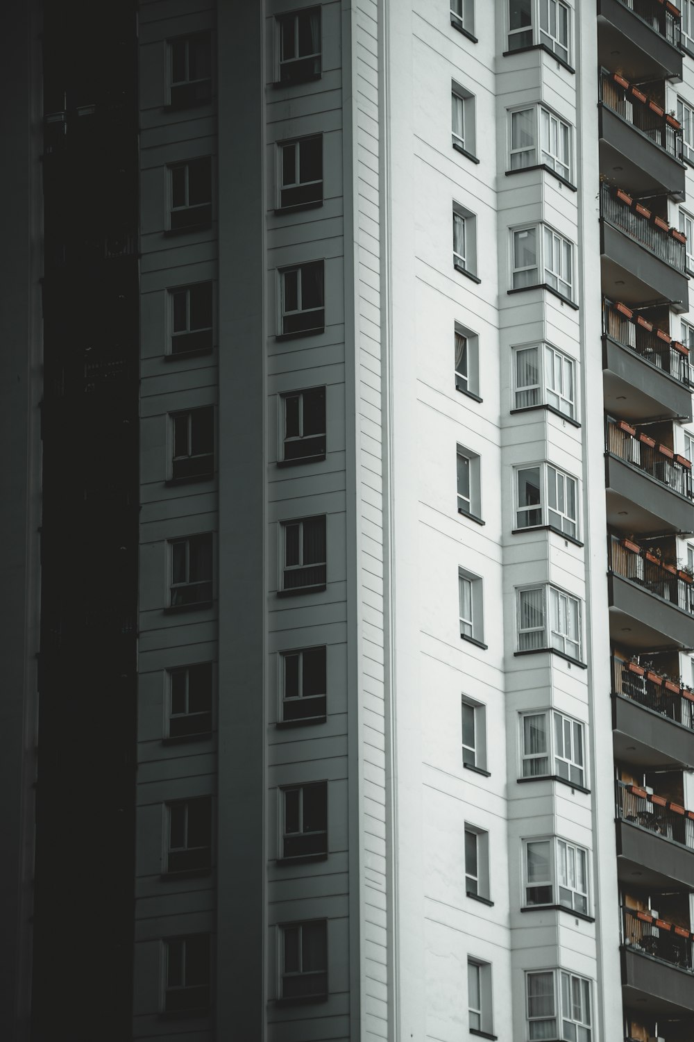 a tall white building with balconies and windows