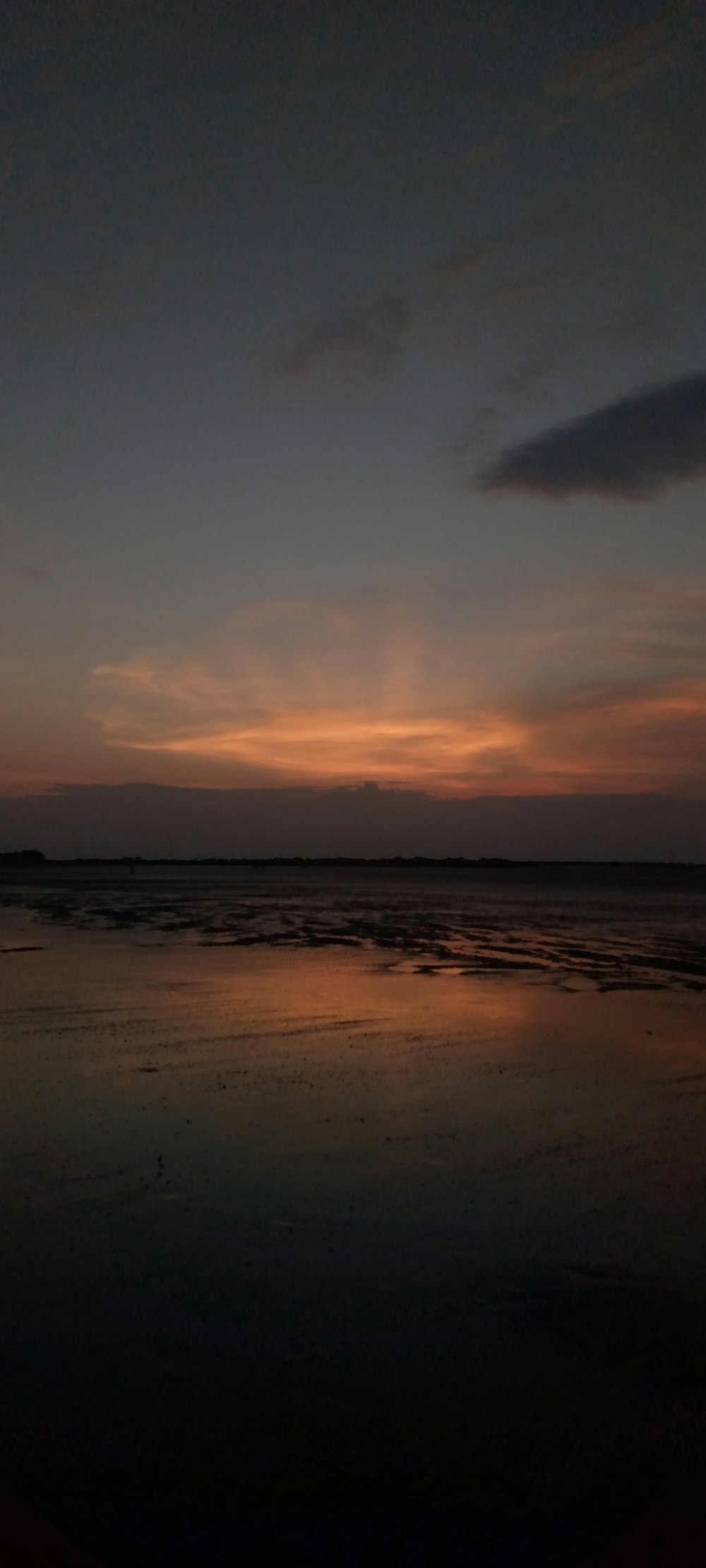 the sun is setting over the water at the beach