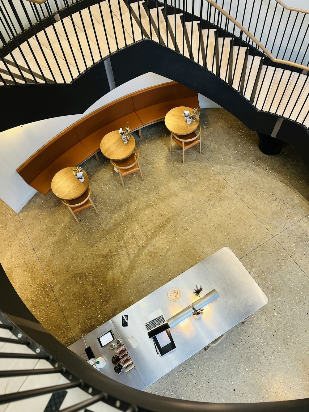 an aerial view of a spiral staircase with a table and chairs