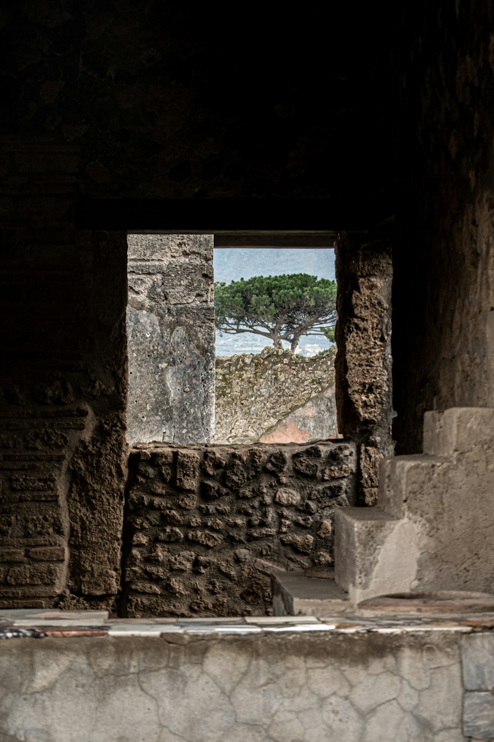 a window in a stone building with a view of the ocean