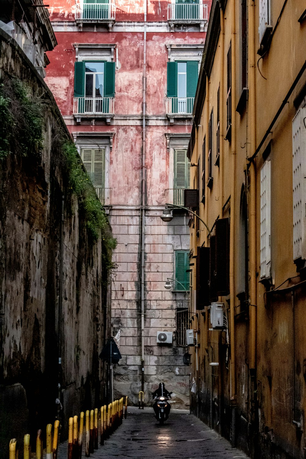 a narrow alley way with a motorcycle parked on the side