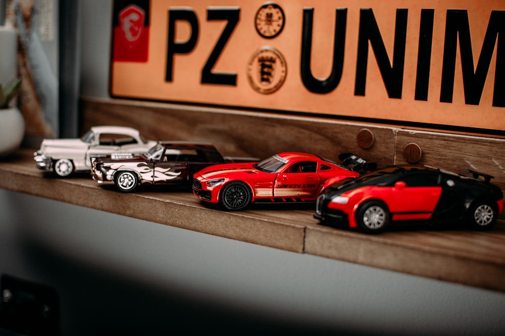 Un grupo de coches de juguete sentados encima de un estante