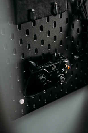 Custom 3D printed gaming accessories including controller grips and decorative stands on a sleek black surface.