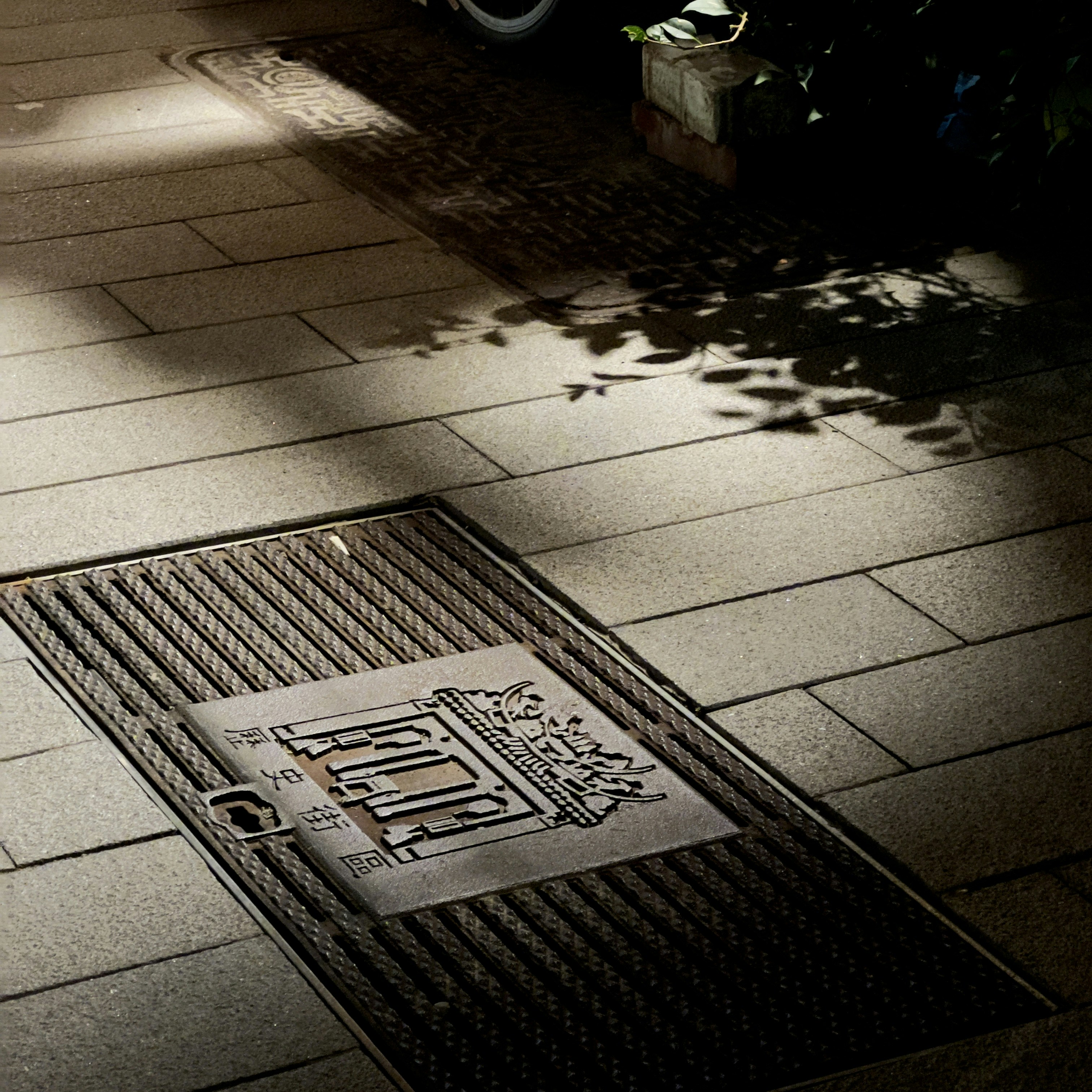 a manhole cover sitting on the side of a sidewalk